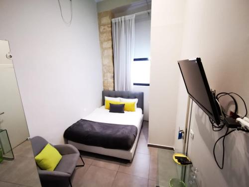 耶路撒冷的住宿－中央精品酒店，一间卧室配有一张床,并在一间客房内配有电视。