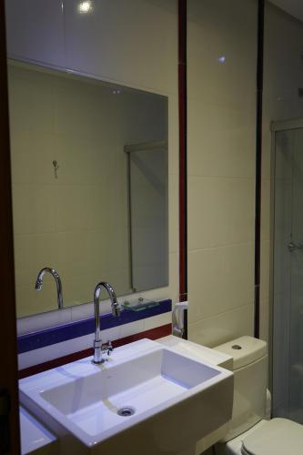 a bathroom with a sink and a mirror and a toilet at Pak Suítes Hotel in Luis Eduardo Magalhaes