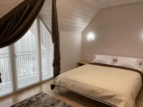 a bedroom with a bed and large windows at Вілла Джерело in Skhidnitsa