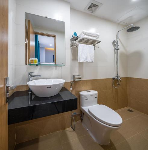a bathroom with a sink and a toilet and a mirror at ST Motel & Apartment in Danang