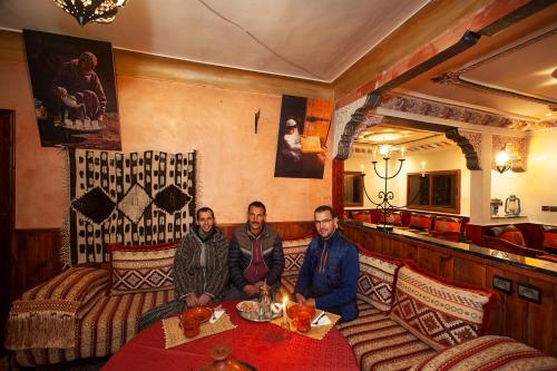 three people sitting at a table in a restaurant at Dar Adrar in Imlil