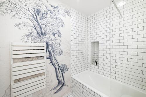 a bathroom with a drawing of a tree on the wall at Citihome Paris in Paris