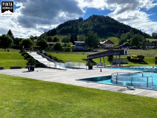 a swimming pool with a slide in a park at Pinta Kombilo Apartments in Gröbming