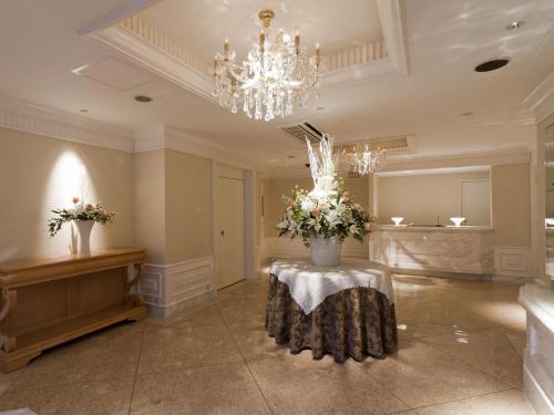 大阪的住宿－Hotel Fine Aroma Dotonbori，配有鲜花和吊灯的桌子的房间