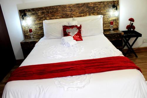 a bedroom with a white bed with a red blanket at Midrand Bed and Breakfast in Midrand