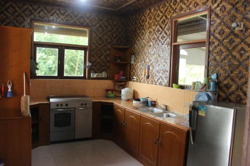 uma cozinha com um frigorífico de aço inoxidável e um lavatório em Salak Sunrise Homestead em Bogor