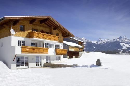 a house in the snow with mountains in the background at Sammer's Rosenchalet in Tannheim