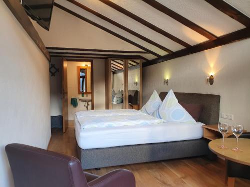 a bedroom with a large bed and a table and chairs at Ferienweingut Stein in Valwig