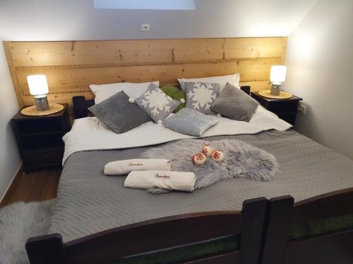 a large bed with pillows and blankets on it at Szymoszkowa Residence Ski & basen sauny jacuzzi - apartament Szara Owca in Kościelisko