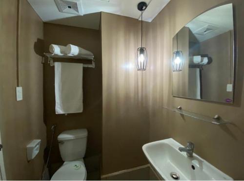 ein Badezimmer mit einem WC, einem Waschbecken und einem Spiegel in der Unterkunft Twin Bed Unit- MIGAs Haven at Sunvida Tower in Cebu City