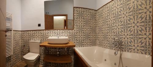 a bathroom with a sink and a tub and a toilet at Casa Gabaldá Apartamentos in Valderrobres