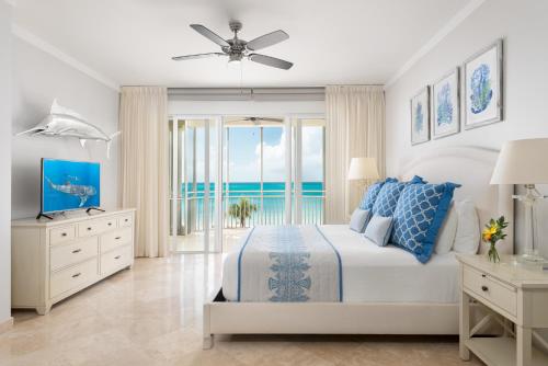 a bedroom with a bed and a view of the ocean at The Venetian on Grace Bay in Grace Bay