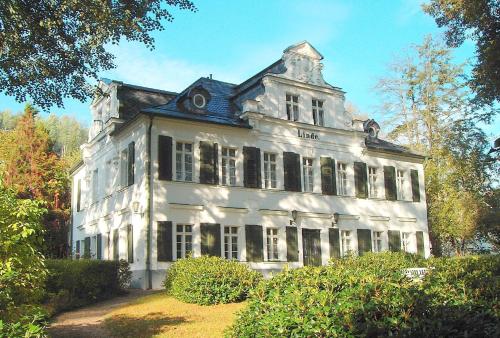 a large white building with a gambrel roof at Kurheim Haus Linde in Bad Elster
