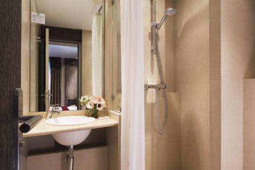 y baño con lavabo y ducha. en Central Hotel Paris, en París
