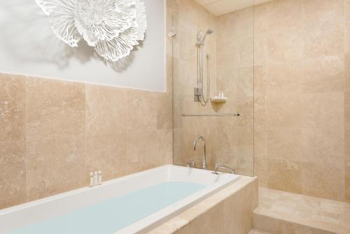 Das Bad ist mit einer Badewanne und einer Dusche ausgestattet. in der Unterkunft The Venetian on Grace Bay in Grace Bay