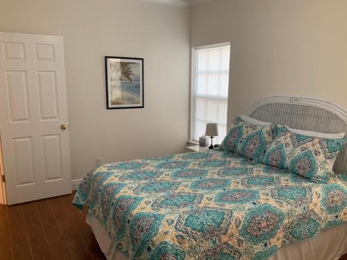 ein Schlafzimmer mit einem Bett mit einer Decke und einem Fenster in der Unterkunft Sun Dancer #11 in South Padre Island