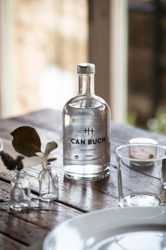 a bottle of gin sitting on top of a wooden table at ECOTurisme Can Buch HOTEL in Sant Aniol de Finestras