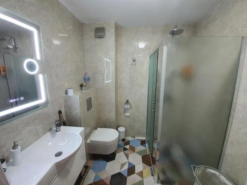ein Badezimmer mit Toilette, Waschbecken und Dusche in der Unterkunft GUEST SUITE Narodno horo in Sofia