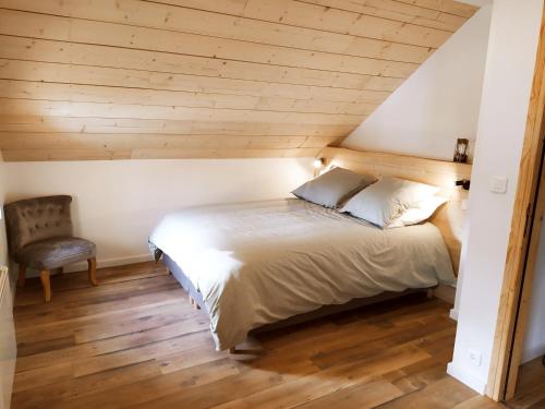 Longevilles-Mont-dʼOrにあるGîte du Fourpéret-Parc Naturel du Haut-Juraのベッドルーム1室(ベッド1台、椅子付)