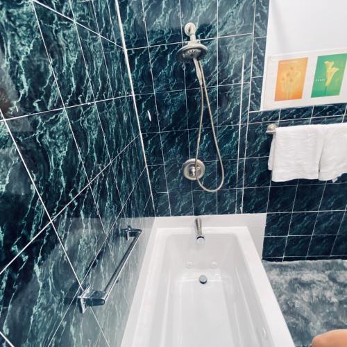 a bathroom with a tub and a green marble wall at Nice 2 bedrooms, Massage Seat, close to New York, THE BEST CHOICE!! in North Bergen