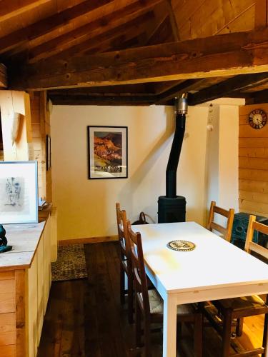- une salle à manger avec une table et un poêle à bois dans l'établissement Appartement de montagne Briançon, à Briançon
