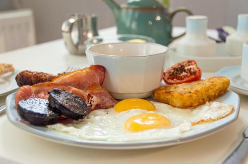 a plate with eggs and other breakfast foods on a table at The Belmont in Torquay