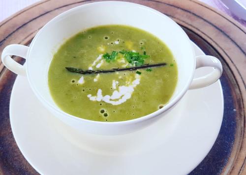 a white bowl of broccoli soup on a plate at Gites-Terroirs-Occitanie in Felluns
