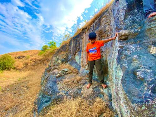 a young child is climbing on a rock wall at Jandyal Farm House in Malshej Ghat