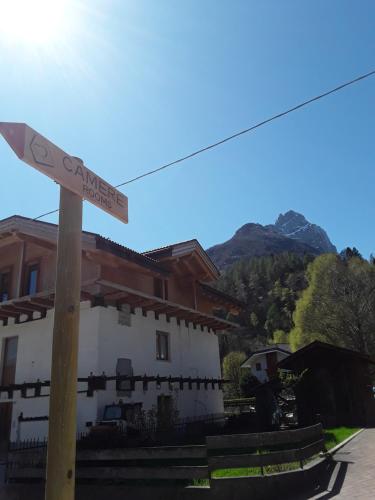 a street sign on a pole in front of a building at Camere Nordest Sudest- Conca Agordina in Agordo
