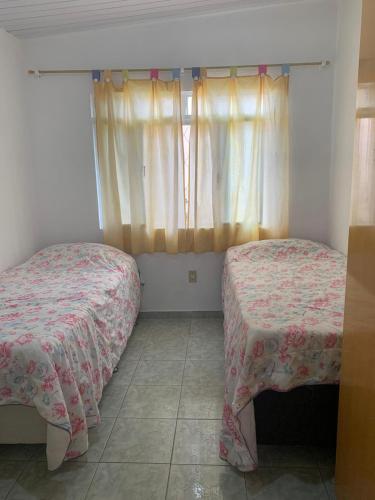 een kleine slaapkamer met 2 bedden en een raam bij Baixo Guandu, casa independente no Centro. in Baixo Guandu