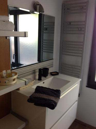 a bathroom with a sink with a mirror and a window at Grain de folie in Beaune