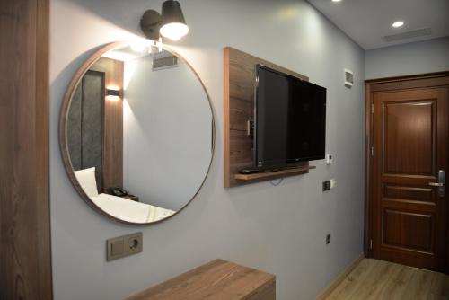 a bathroom with a mirror and a tv on a wall at Basilissis Hotel in Istanbul