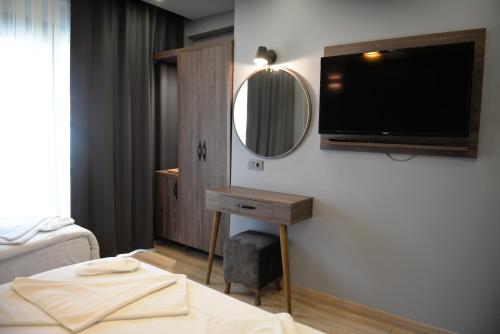 a bedroom with a bed and a tv on a wall at Basilissis Hotel in Istanbul