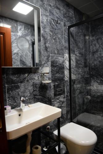 a bathroom with a sink and a shower and a toilet at Basilissis Hotel in Istanbul