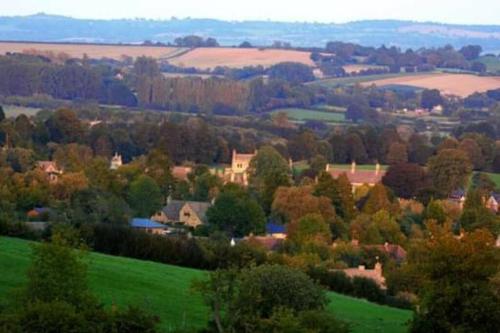 a small town in a green field with trees at Castle Hideaway in the Cotswolds in Chipping Campden