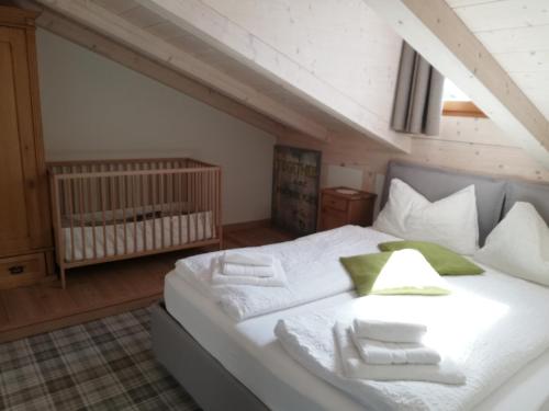 a bedroom with a large white bed with a crib at Casa Lassù. in Carano