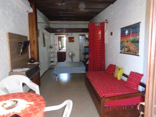 a living room with a red couch and a bed at Francais in La Paloma