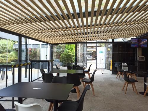 un restaurante con mesas, sillas y ventanas en Casa Mar Da Villa Restaurant Hotel, en Noia