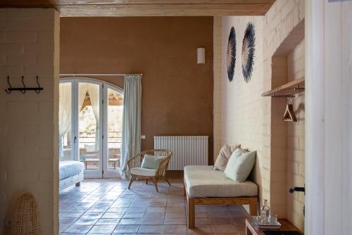 a living room with a couch and a chair at ECOTurisme Can Buch HOTEL in Sant Aniol de Finestras