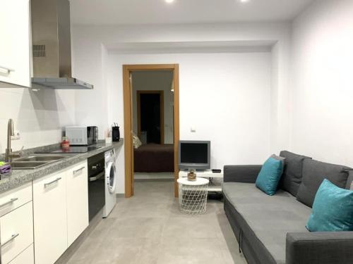 cocina y sala de estar con sofá y TV en UIM Mediterraneo PB Aragon A Wifi en Puerto de Sagunto