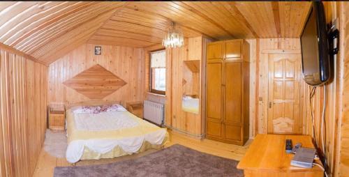 a bedroom with a bed in a wooden cabin at Cottage Gutsulia in Yaremche