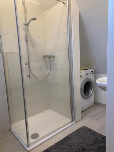a shower stall in a bathroom with a washing machine at City Apartment in Lörrach