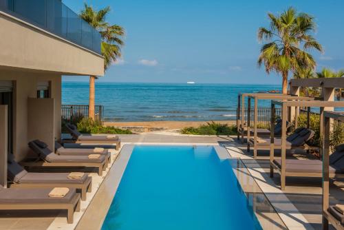 a resort with a swimming pool and the ocean at Riviera Boutique Hotel in Stalida