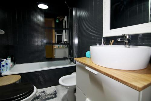 uma casa de banho com um lavatório branco e um WC. em Las tres Biznagas em Málaga