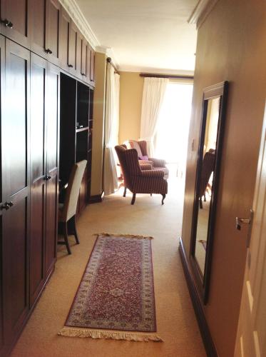 a hallway with a living room with a chair and a rug at Burnham House B&B in Durban