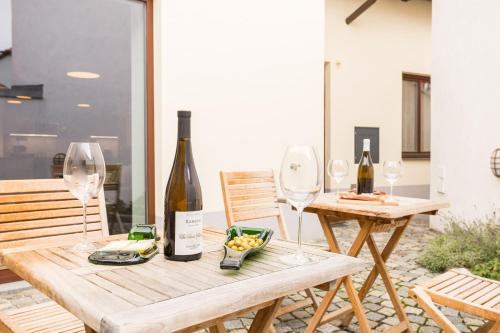 a table with two wine glasses and a bottle of wine at Vinný apartmán Rakovník in Rakovník