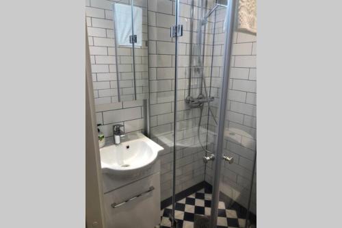 a bathroom with a sink and a shower at Captain’s Cabin Jakobstad Pietarsaari center in Pietarsaari