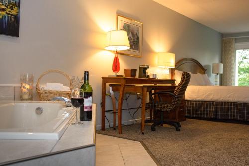 West Bay的住宿－鄧迪高爾夫俱樂部度假村，浴室设有1张床和1张带1瓶葡萄酒的书桌。