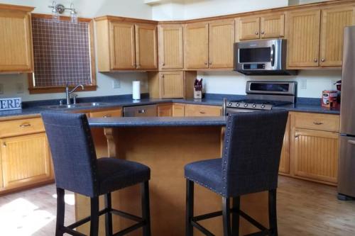 a kitchen with a counter and two bar stools at Beautiful Tranquil Mountain Home in Andrews, NC in Andrews