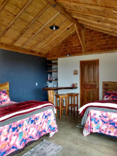 a bedroom with two beds and a table in a room at Recanto das Estrelas in Aiuruoca